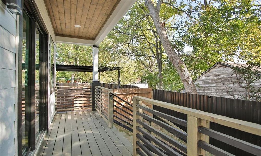 This photo features a cozy wooden covered deck with railing, perfect for relaxing outdoors.