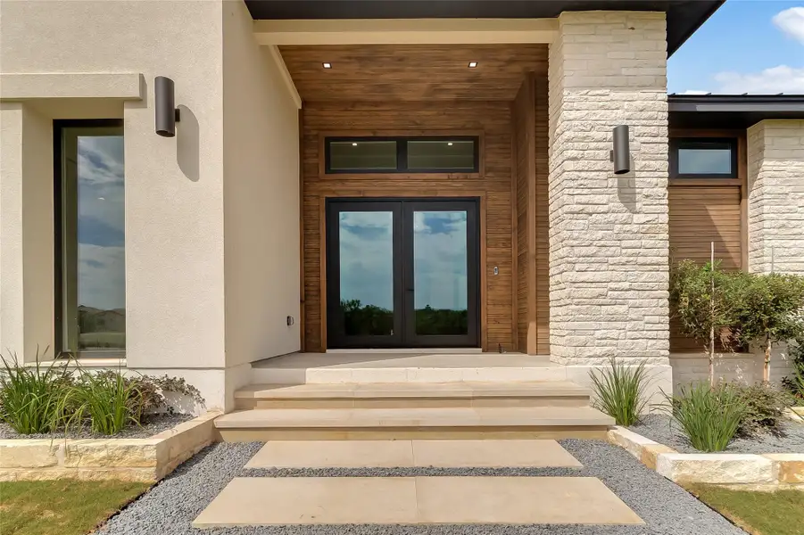 View of exterior entry with french doors, stucco siding, and stone siding View of exterior entry with french doors, stucco siding, and stone siding