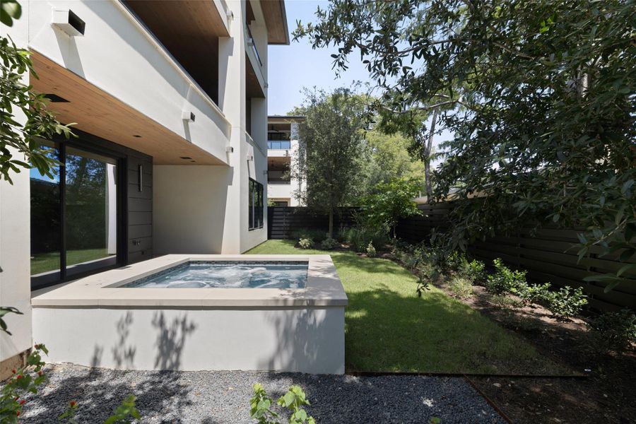 Fenced backyard featuring a hot tub and a patio area