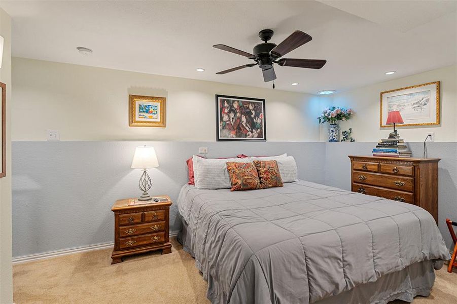 Carpeted room featuring a ceiling fan with integrated lighting, recessed lighting, and a two-tone wall treatment
