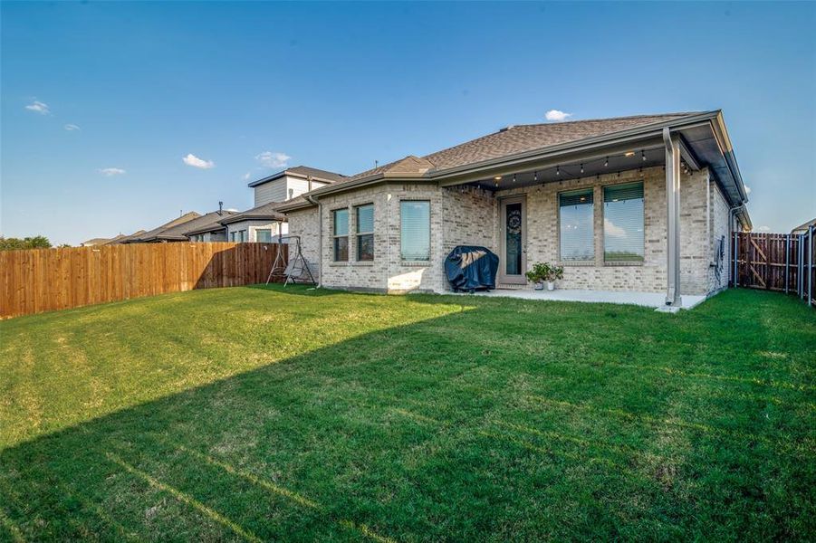 Back of property with a lawn and a patio