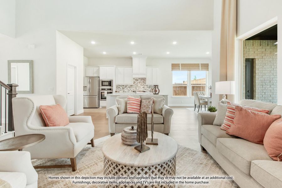 Open-concept living room with neutral sofas, pink accent pillows, and kitchen visible in background Open-concept living room with neutral sofas, pink accent pillows, and kitchen visible in background