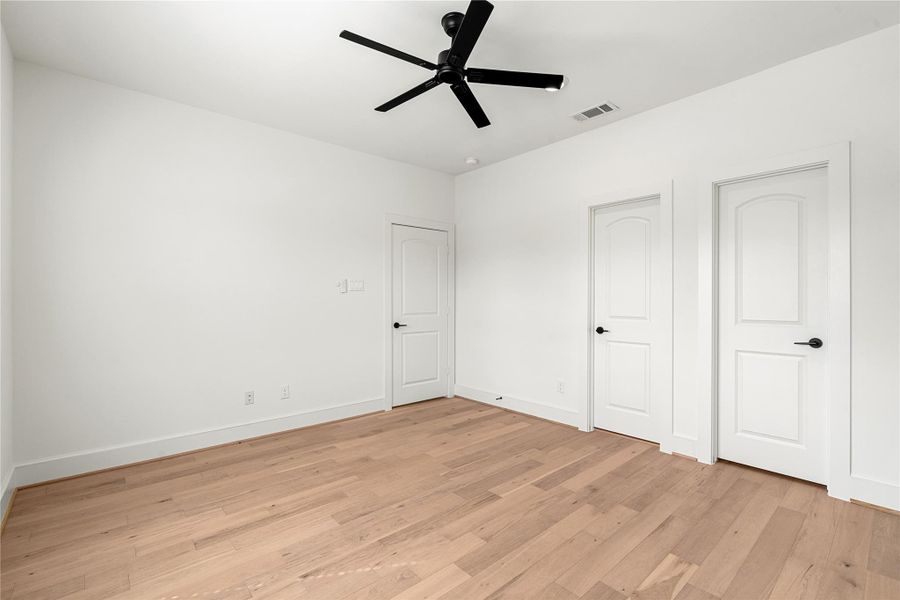 Spacious bedroom featuring a full walk-in closet and a private en-suite bath, offering both comfort and functionality for guests or family members. Spacious bedroom featuring a full walk-in closet and a private en-suite bath, offering both comfort and functionality for guests or family members.