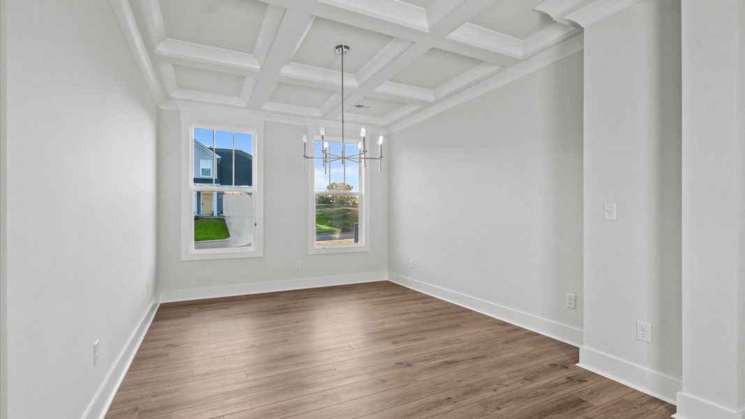 Eye-catching coffered ceiling adds charm to the formal dining space in this superior DRB Homes design