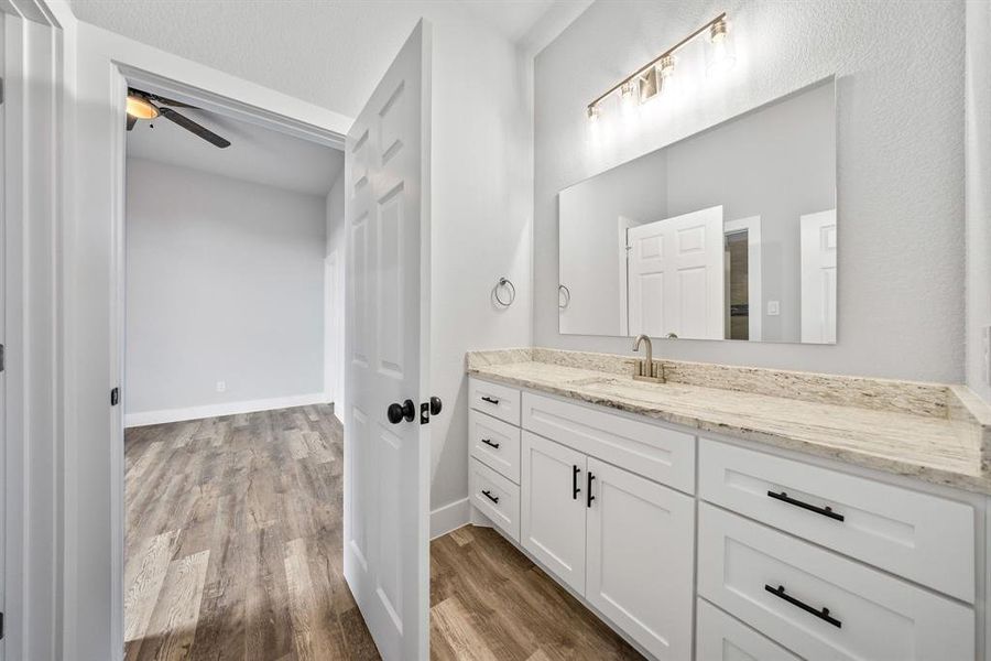 Bathroom featuring light wood-style floors, vanity, and a ceiling fan
