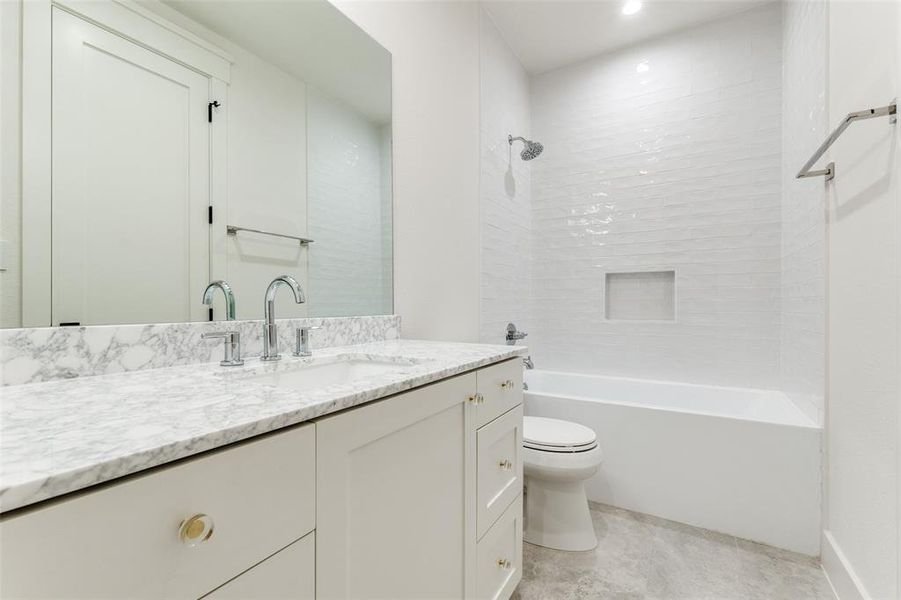 Full bathroom with vanity, toilet, and tiled shower / bath combo