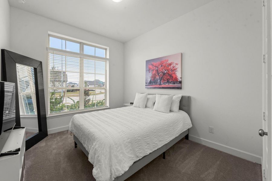 Another secondary bedroom offers lush carpeting, large wall closet, sunny double window with 2” blinds and overhead transom windows, and ceiling light. It has hallway access to the third full bath shared with Bedroom 4.