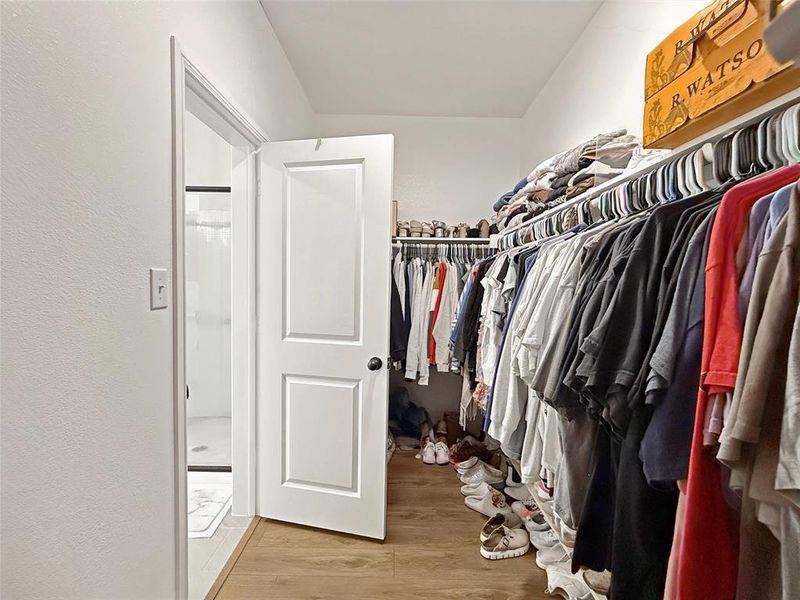 Walk in closet with light wood-style flooring Walk in closet with light wood-style flooring