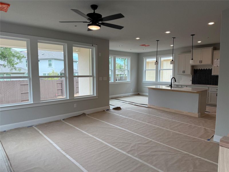 Kitchen with recessed lighting, a center island with sink, light countertops, backsplash, and pendant lighting Kitchen with recessed lighting, a center island with sink, light countertops, backsplash, and pendant lighting