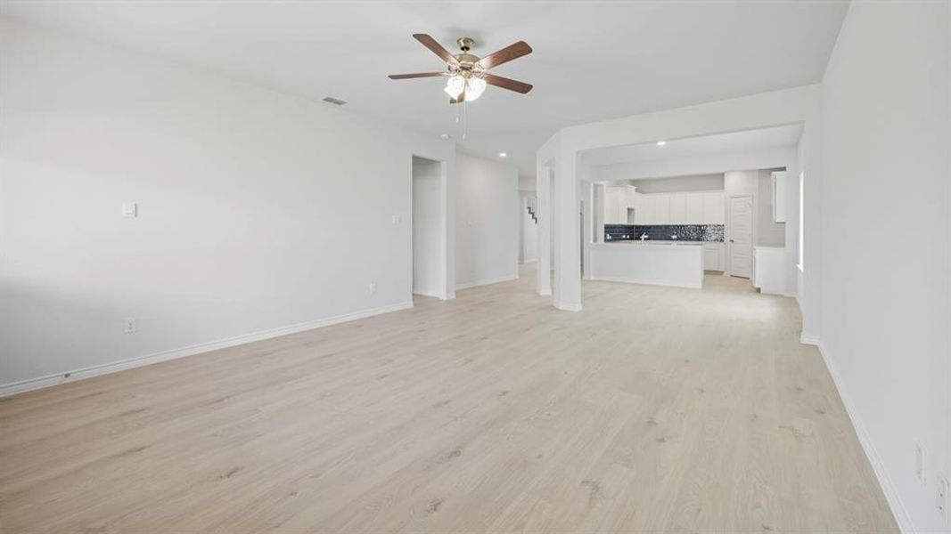 Unfurnished living room with light wood-style flooring, ceiling fan, and recessed lighting Unfurnished living room with light wood-style flooring, ceiling fan, and recessed lighting