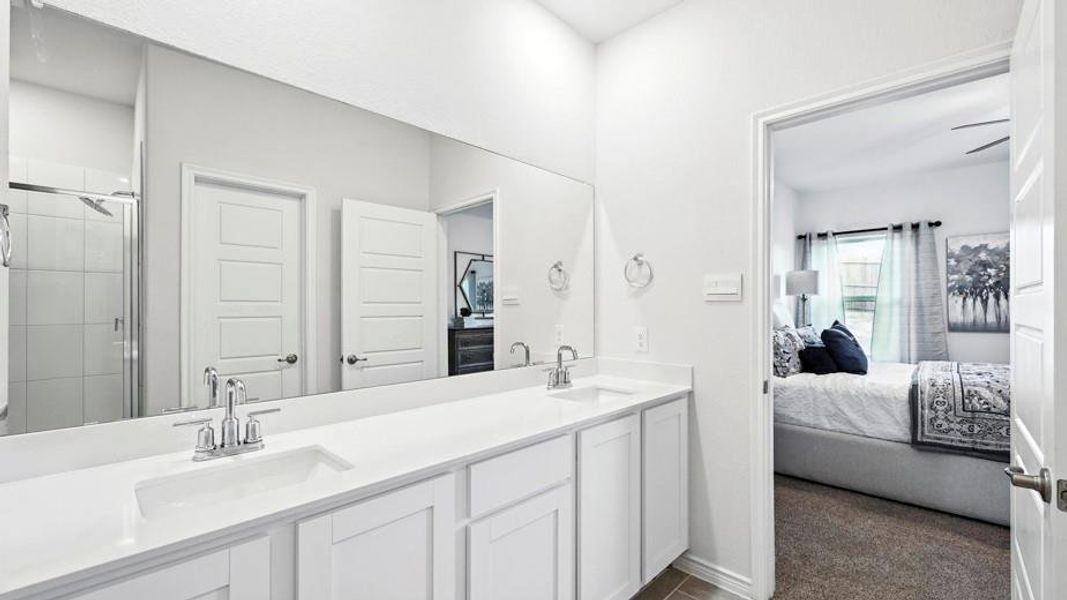 Bathroom featuring a dual vanity with undermount sinks, chrome faucets, and a full-width mirror