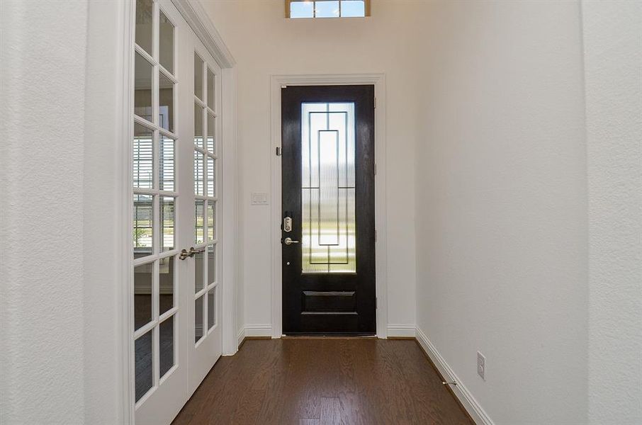 Leaded glass door with wrought iron, wood flooring and 2 story entry