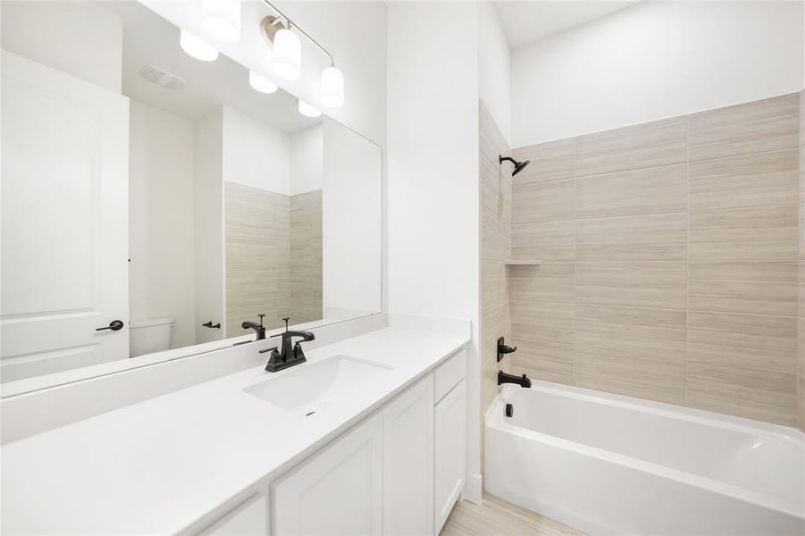 Bathroom featuring tub / shower combination and vanity