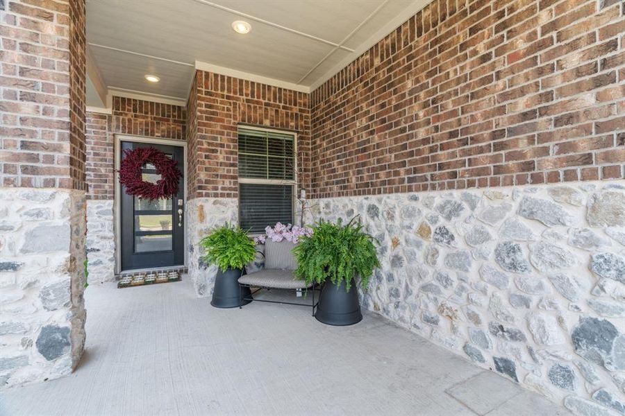 Property entrance featuring a porch and brick siding Property entrance featuring a porch and brick siding