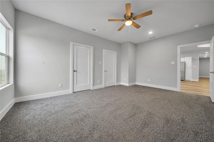 Empty room with ceiling fan and carpet flooring