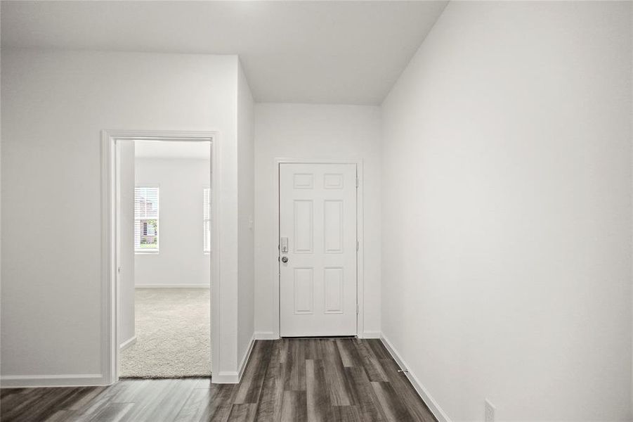 Interior entry corridor with durable flooring and direct access to main living areas and kitchen.