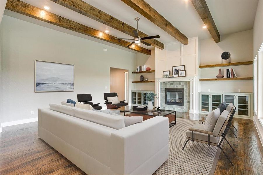 Unfurnished living room featuring beamed ceiling, ceiling fan, and dark wood-type flooring