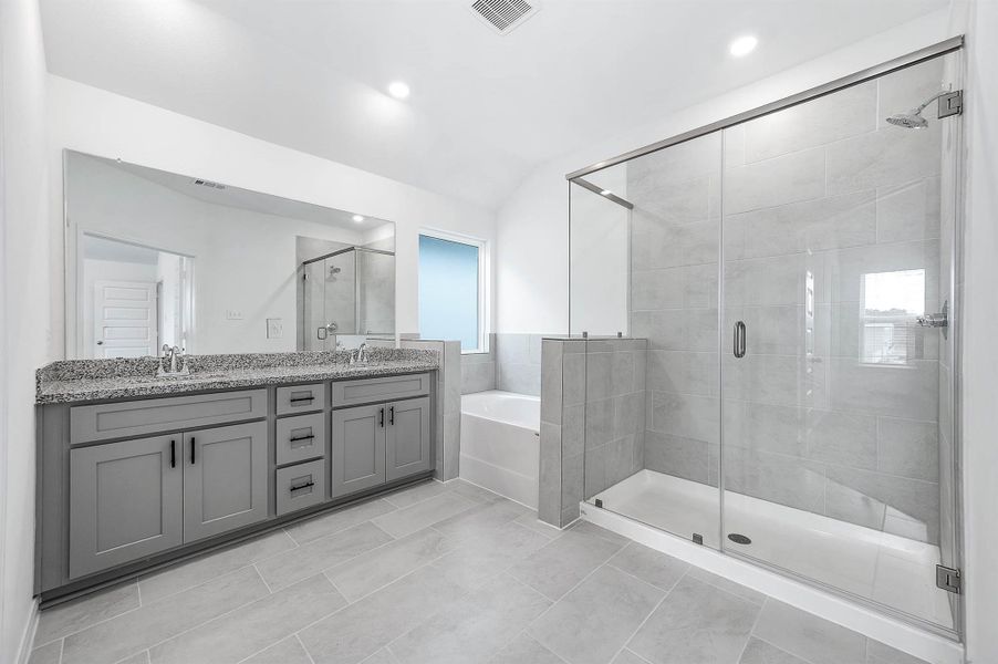 Primary bathroom features dual vanity sinks, a glass-enclosed walk-in shower, and soaking tub. Primary bathroom features dual vanity sinks, a glass-enclosed walk-in shower, and soaking tub.