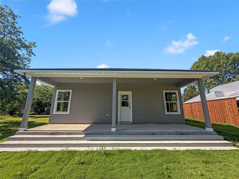 Covered front porch with concrete flooring and multiple steps Covered front porch with concrete flooring and multiple steps