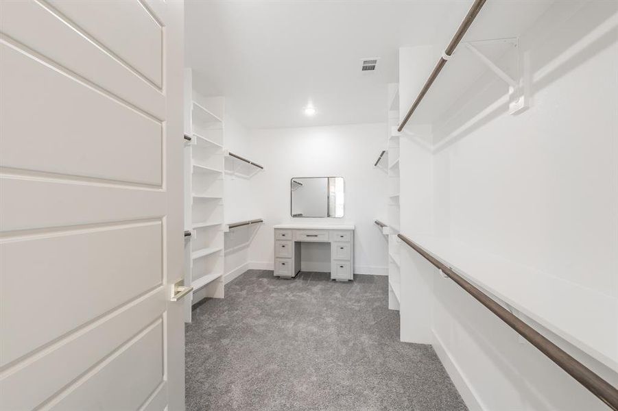 Walk in closet featuring dark carpet
