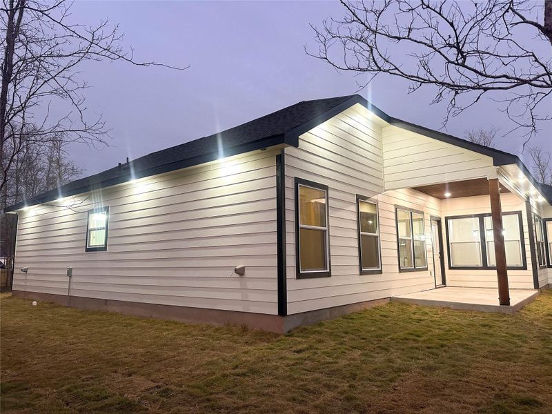 View of home's exterior with a lawn and a patio
