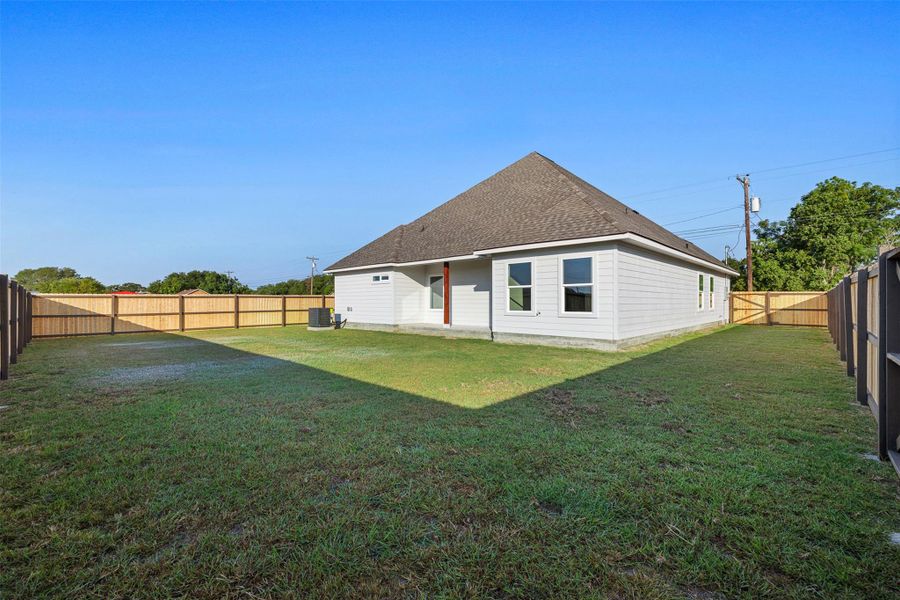 Rear view of house with a patio, a shingled roof, and a fenced backyard Rear view of house with a patio, a shingled roof, and a fenced backyard