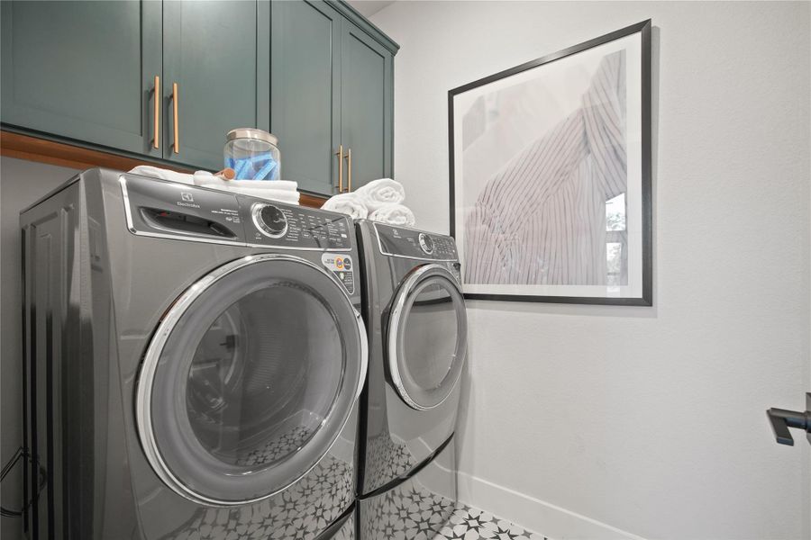 Washroom featuring washer and clothes dryer and cabinet space
