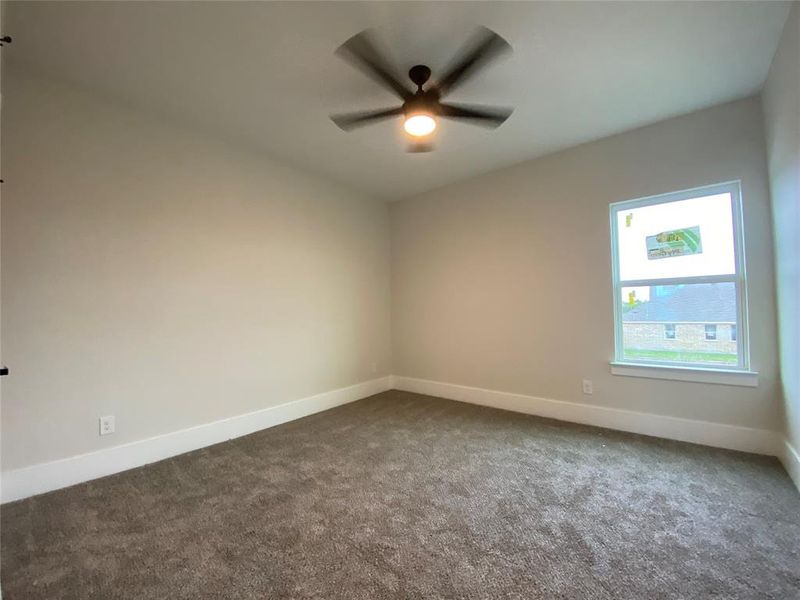 Carpeted empty room featuring ceiling fan