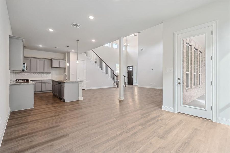Unfurnished living room featuring light wood-style flooring and recessed lighting Unfurnished living room featuring light wood-style flooring and recessed lighting