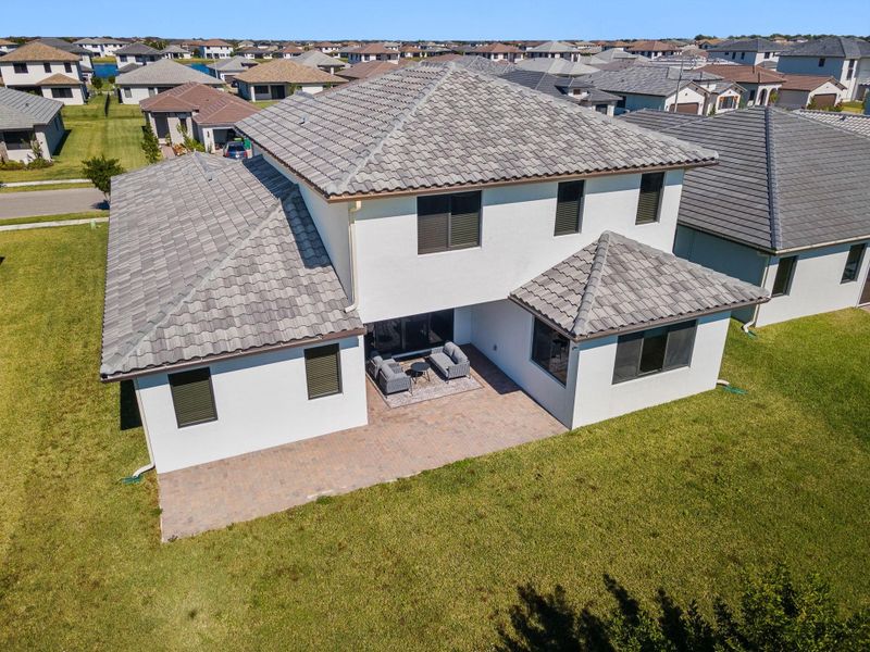 Rear view of property with stucco siding, a yard, a residential view, and a patio area