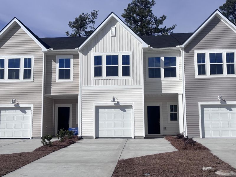 Front exterior of a new home in Lindera Preserve at Cane Bay Plantation: Townhomes, Summerville, SC, highlighting curb appeal (Image 1). Front exterior of a new home in Lindera Preserve at Cane Bay Plantation: Townhomes, Summerville, SC, highlighting curb appeal (Image 1).
