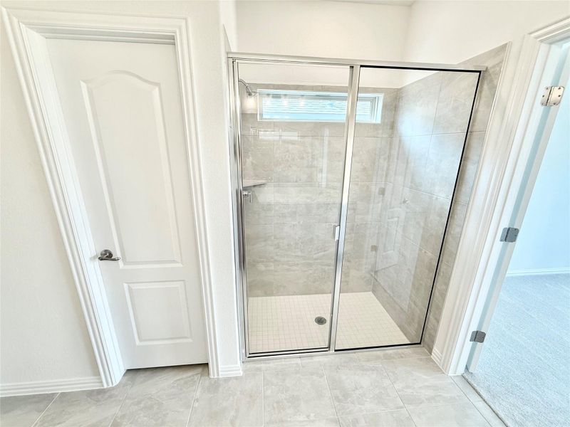 Full bathroom with a shower stall and baseboards Full bathroom with a shower stall and baseboards