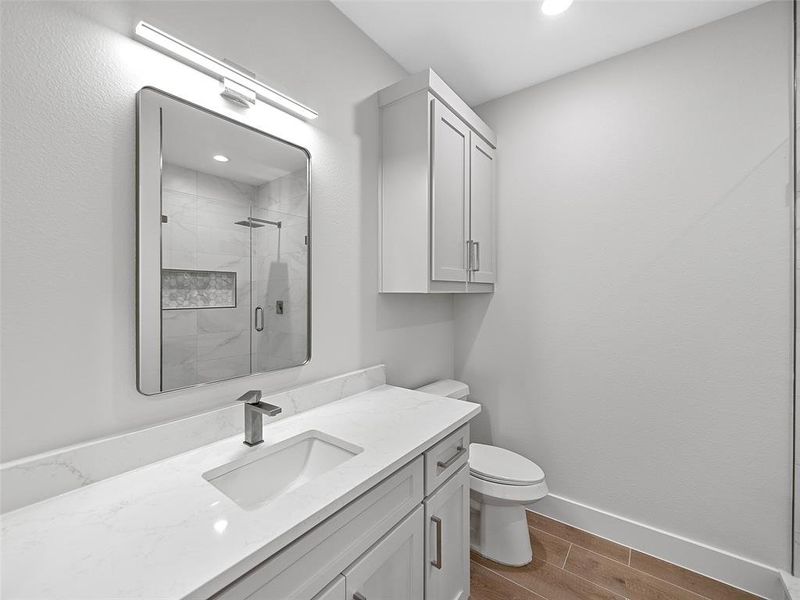 Bathroom 2 with a shower door, vanity, and toilet