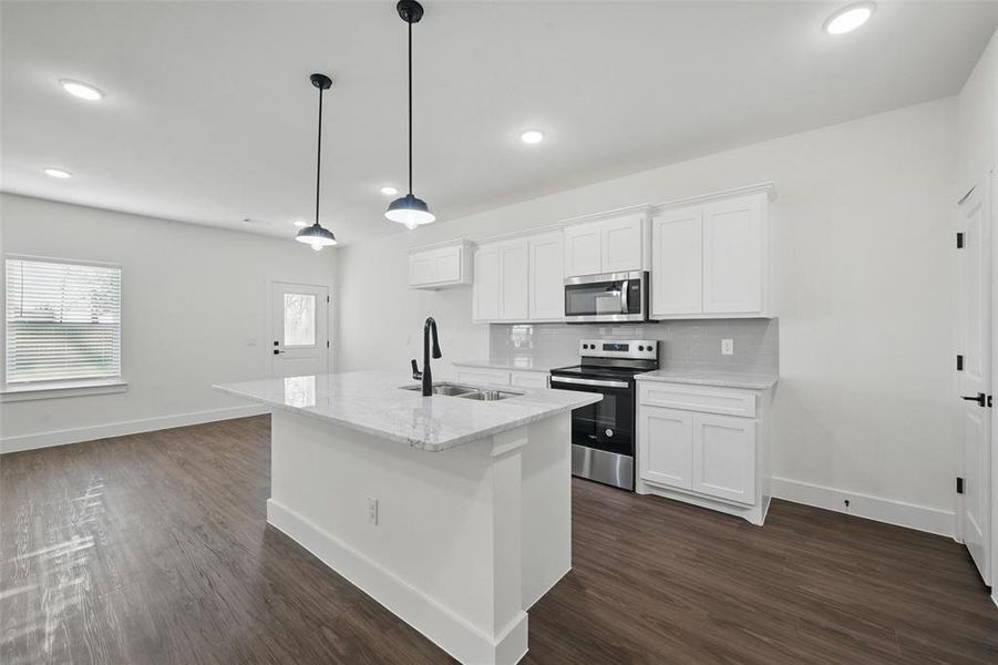 Kitchen featuring a sink, stainless steel appliances, dark wood-type flooring, and decorative backsplash Kitchen featuring a sink, stainless steel appliances, dark wood-type flooring, and decorative backsplash