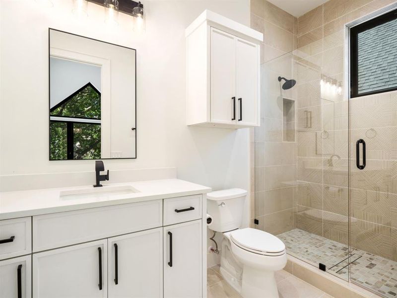 Full bathroom with a shower stall, vanity, and light tile patterned floors