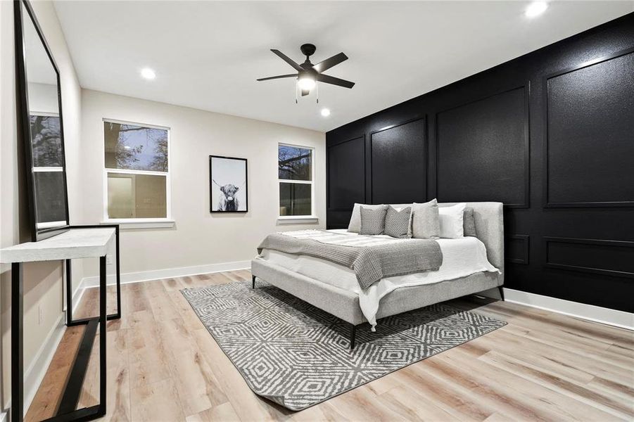 Bedroom with light wood finished floors, a decorative wall, a ceiling fan, and recessed lighting Bedroom with light wood finished floors, a decorative wall, a ceiling fan, and recessed lighting