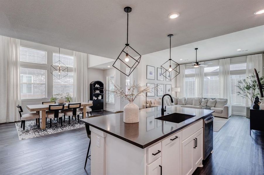 Kitchen with pendant lighting, white cabinetry, a chandelier, open floor plan, and a center island with sink
