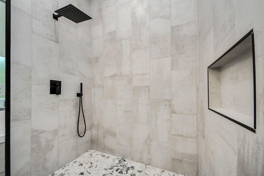 Spa-inspired primary bathroom featuring a large walk-in shower with sleek tile surround and modern fixtures. Open, airy design and clean finishes create a relaxing, resort-style experience right at home.