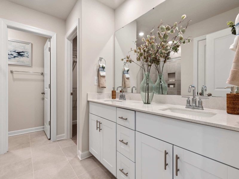 The primary bathroom features a walk-in closet and dual vanities.