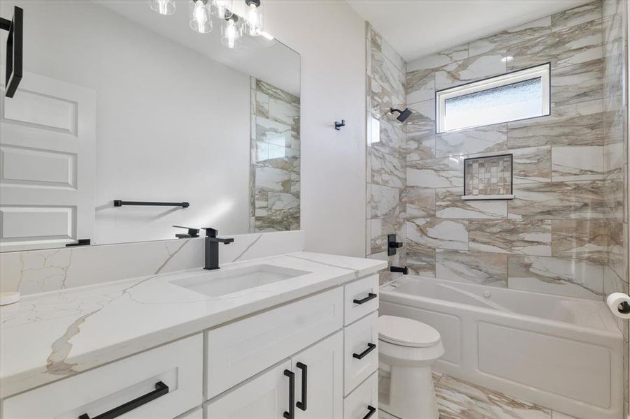 Full bathroom with toilet, marble finish floor, vanity, and shower / bathtub combination