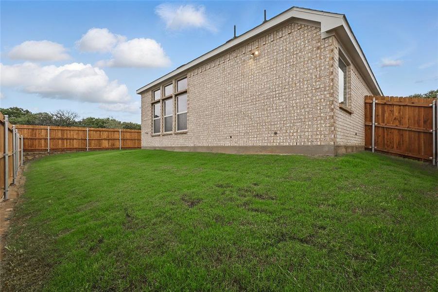View of side of home with brick siding and a fenced backyard View of side of home with brick siding and a fenced backyard