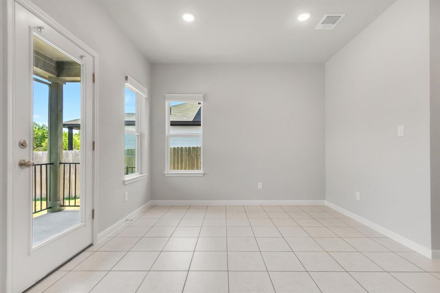 Recessed lighting illuminates this bright room with a glass-paneled door opening to the outdoors.