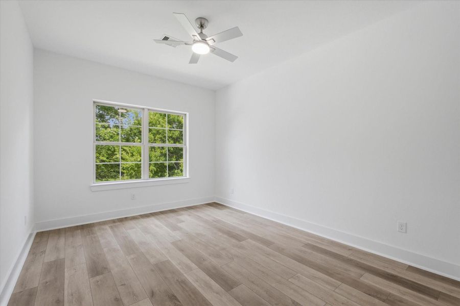 Another second-floor bedroom, complete with luxury vinyl flooring, a remote-control ceiling fan, and a spacious closet. Another second-floor bedroom, complete with luxury vinyl flooring, a remote-control ceiling fan, and a spacious closet.