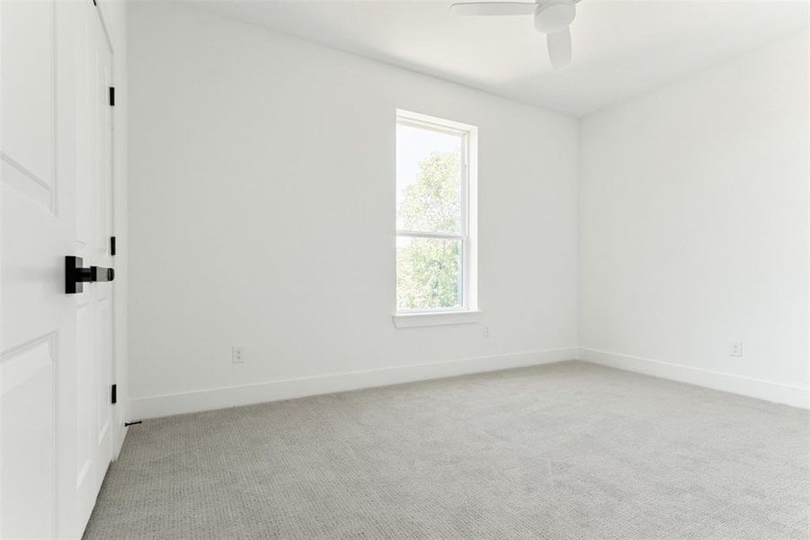 Carpeted spare room featuring ceiling fan