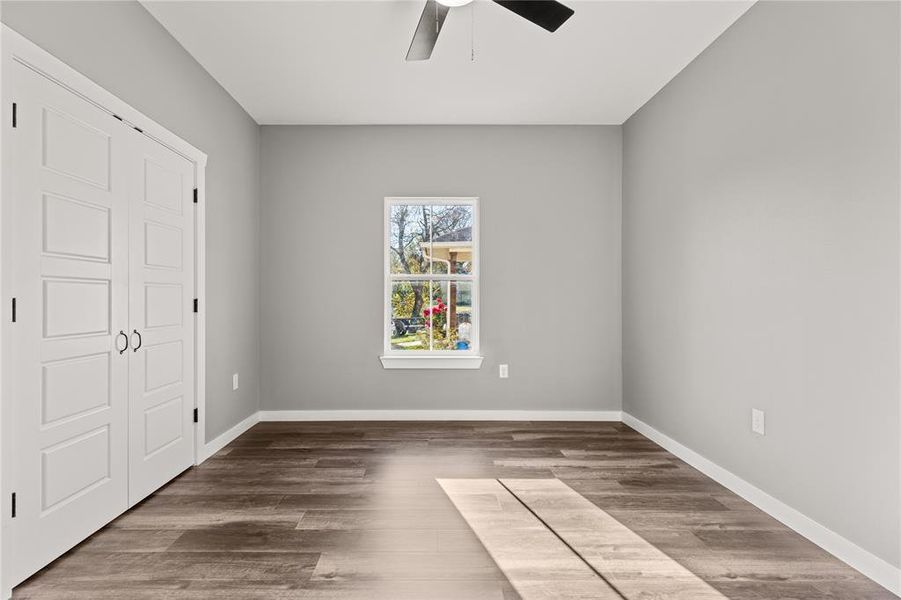 Unfurnished bedroom featuring wood finished floors and a ceiling fan