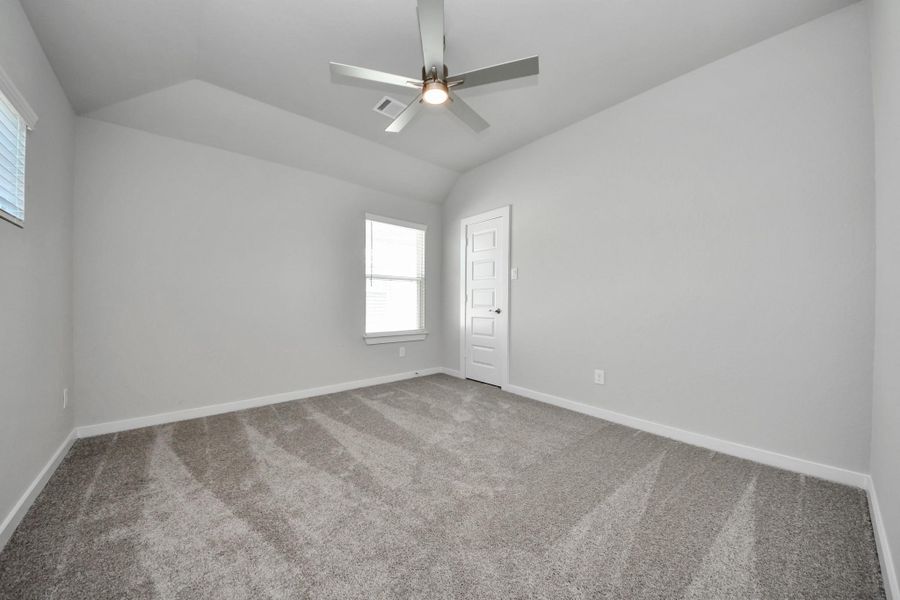 Secondary bedroom features plush carpeting, large windows that let in plenty of natural light, bright paint, and spacious closets.