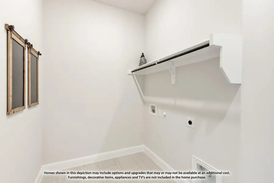 Laundry room with white wall-mounted shelf, hanging rod, washer hookups, and barn door hardware on white walls.