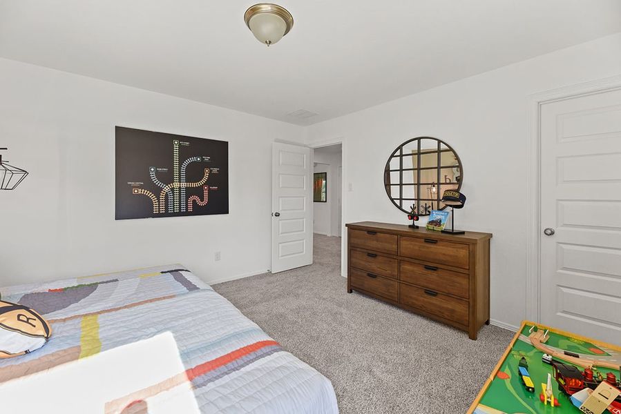 A bedroom with a bed and dresser.