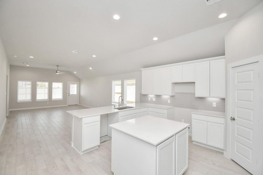 The kitchen is a culinary haven, featuring granite countertops, a tile backsplash, stainless steel appliances, 42” upper cabinets, and undercabinet lighting. Sample photo of completed home with similar floor plan. Actual colors and selections may vary.