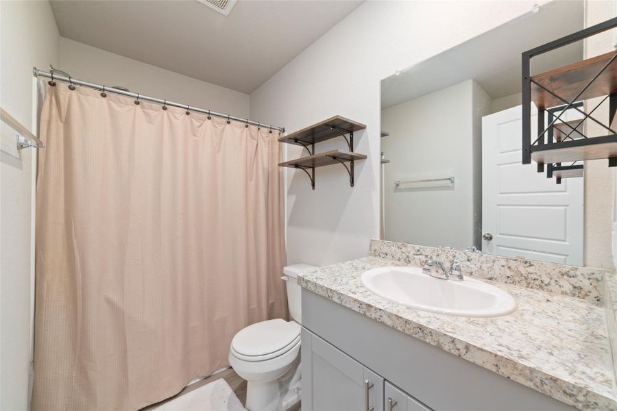 Clean secondary bathroom with bright lighting and a spacious vanity, creating a fresh and open feel.